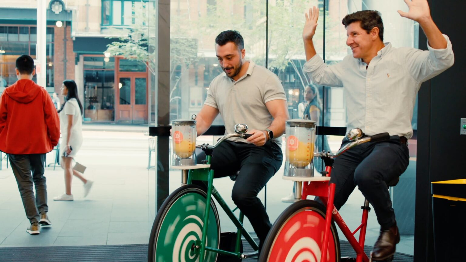 Two guys in suits on smoothie bikes, having fun at the workplace wellbeing activation