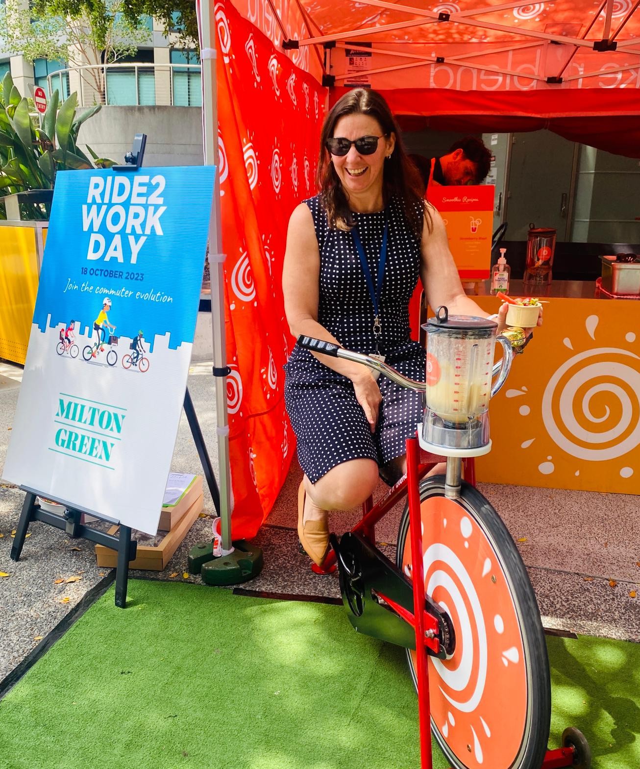 A woman smiling and enjoying the inclusive physical activity of a smoothie bike for Ride 2 Work Day